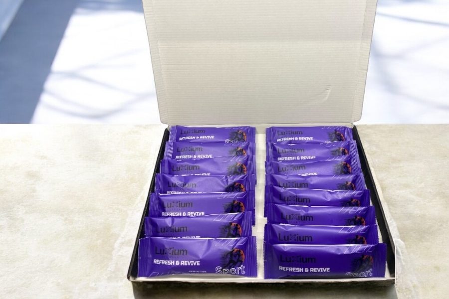 Luxium Sport 15-pack box open showing individually wrapped towels